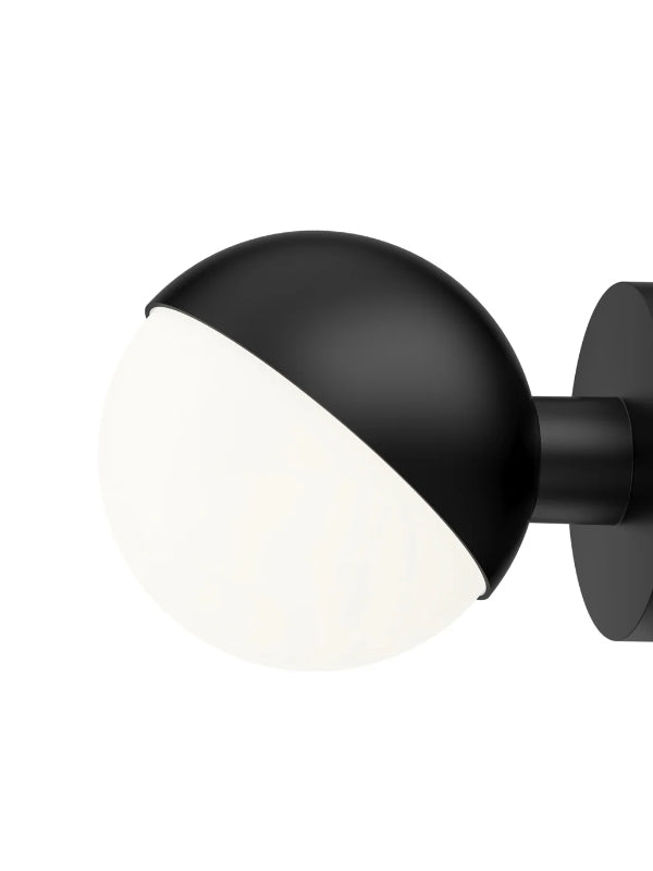 Black wall-mounted light fixture with a white bulb on a white background
