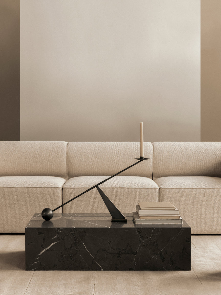 Modern living room with a beige sectional sofa and a black marble coffee table.