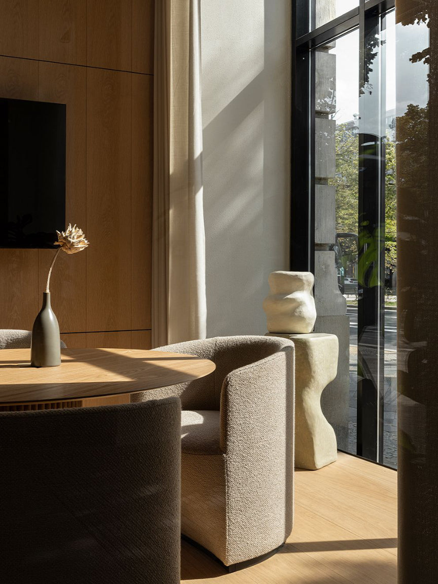 Modern interior with a wooden table, gray chairs, and decorative vases.