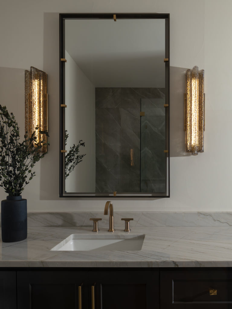 Bathroom vanity with mirror, faucet, and decorative elements.