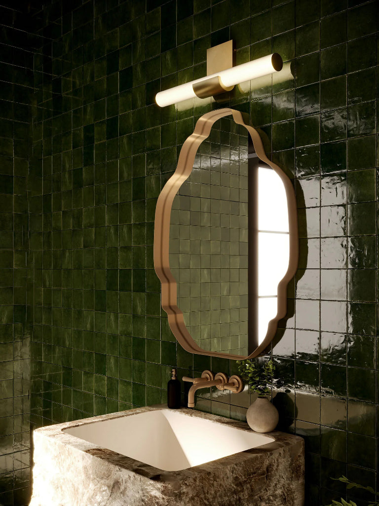 Bathroom with green tiled walls, a mirror, and a sink.