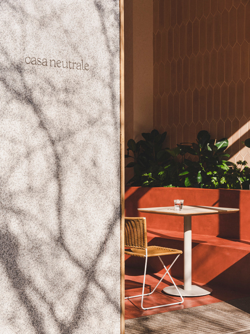 Interior design with a marble texture on the left and a modern dining area on the right - Casa Neutrale
