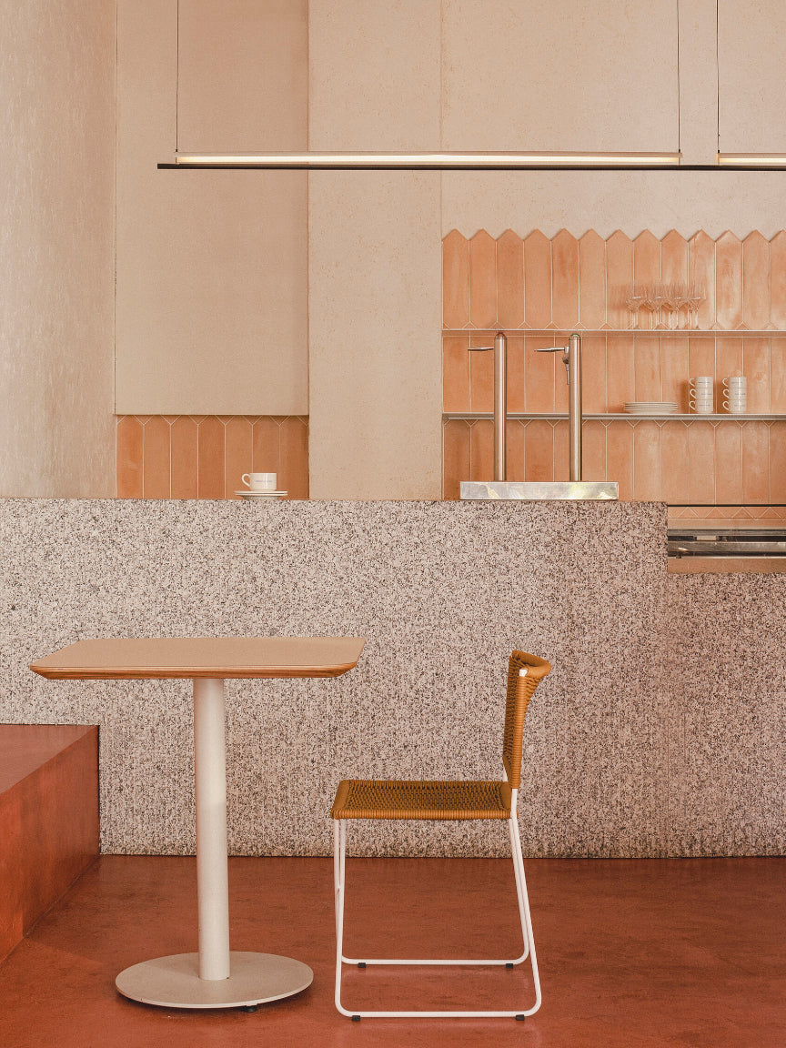 Modern kitchen with a table and chair in the foreground - Casa Neutrale