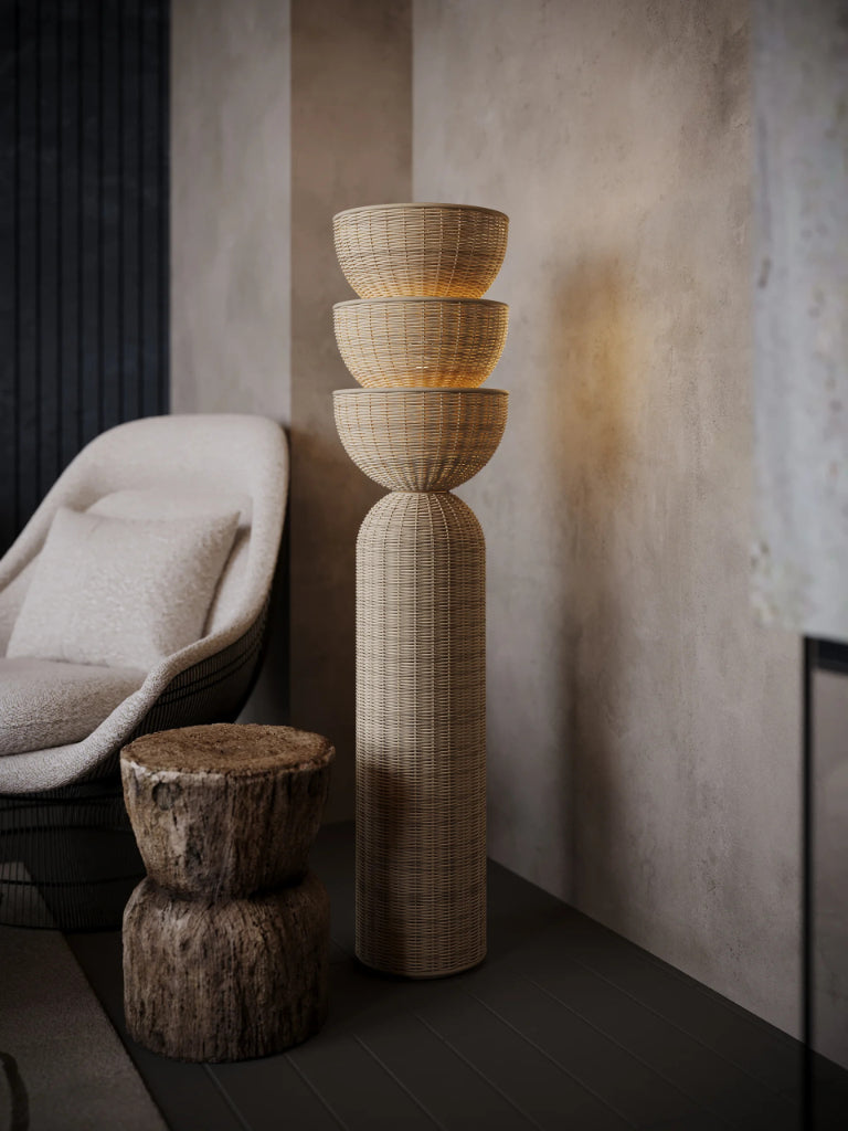 Woven floor lamp with a textured wall and chair in the background
