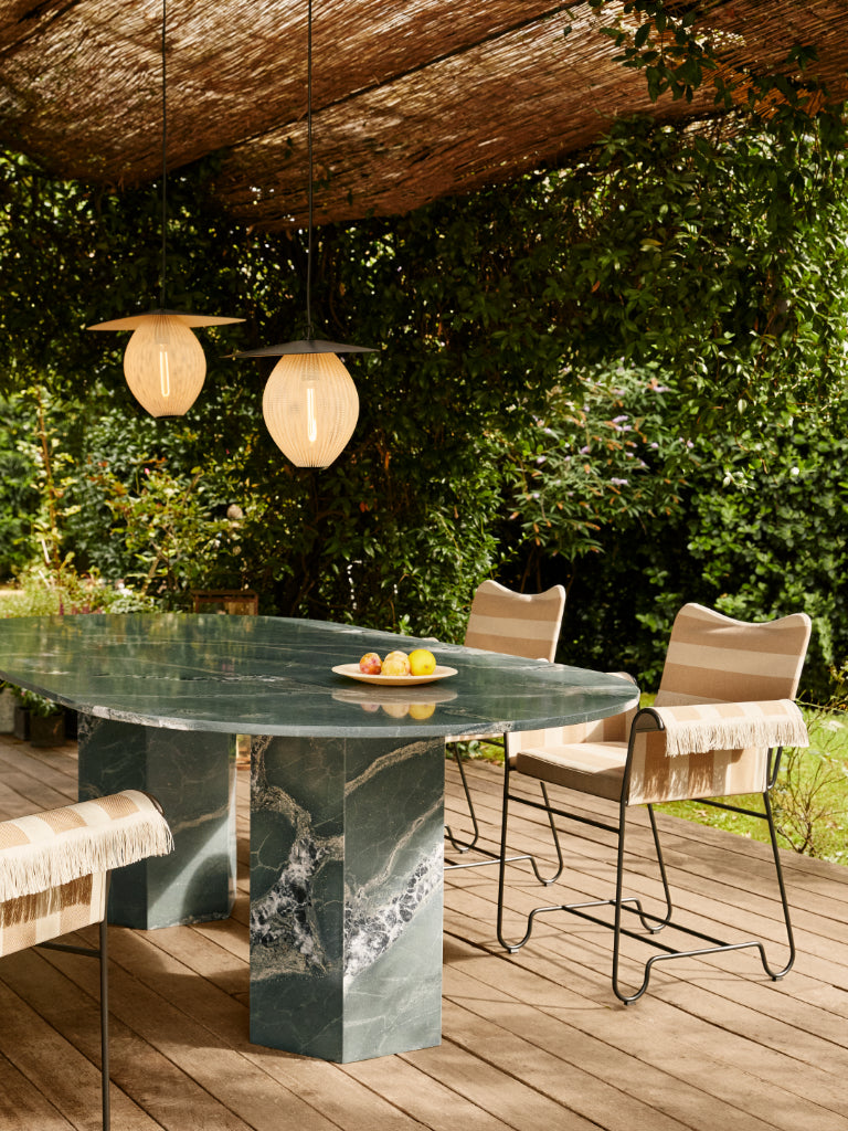 Outdoor setting with a marble table and chairs under a wooden canopy.