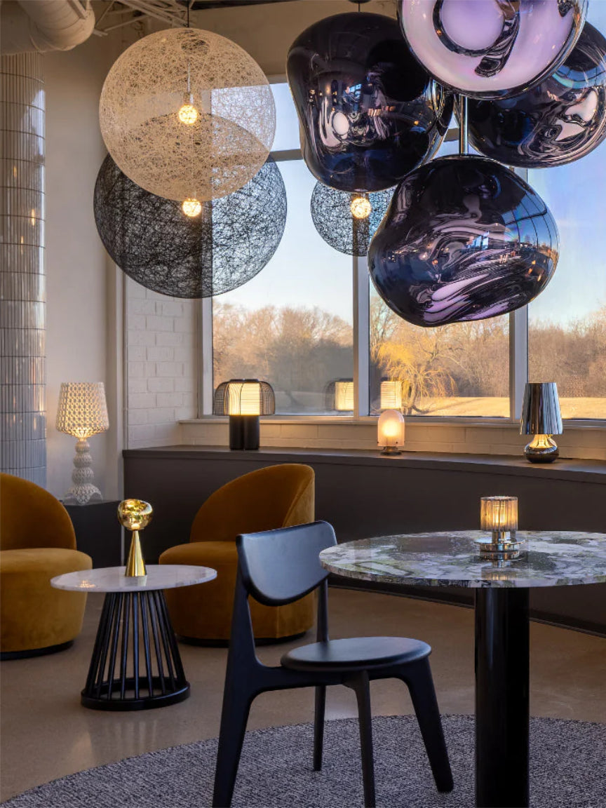 Modern interior design with spherical pendant lights and a round table.