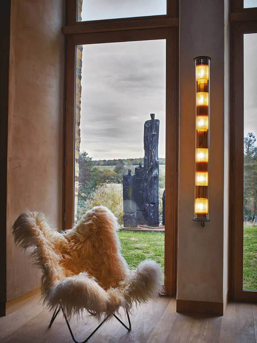 Furry chair in a room with large windows showing an outdoor sculpture.