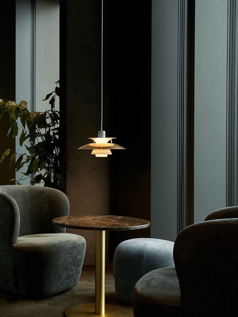 Modern interior with a pendant light, round table, and gray chairs.