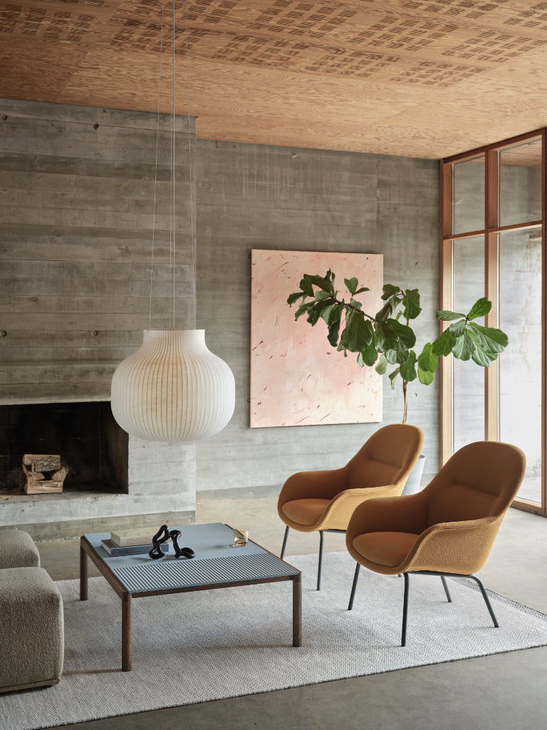 Modern living room with brown chairs, a coffee table, and a fireplace.