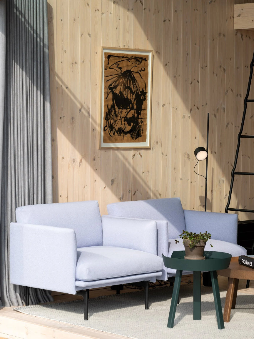 Modern living room with a light blue sofa, green side table, and abstract art on the wall.