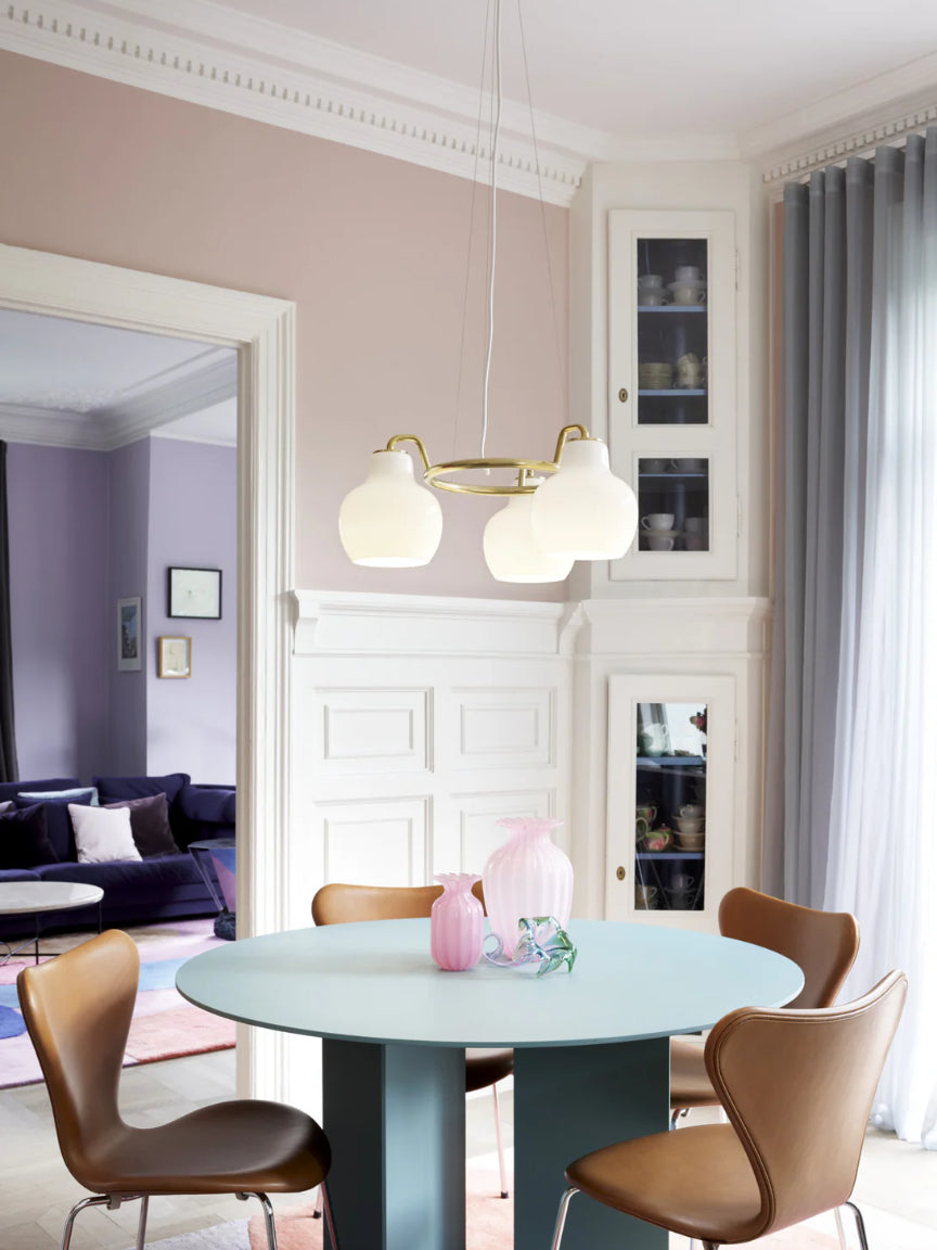 Dining room with a round table and chairs, featuring a chandelier and a cabinet.