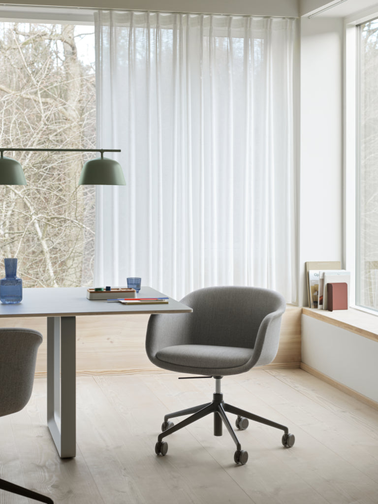 Modern office space with a desk, chairs, and large windows.