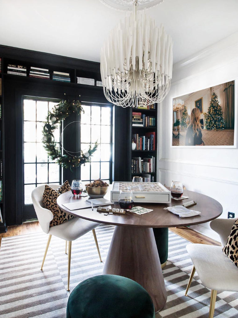 Modern dining room with a round wooden table, chairs, and decorative elements.