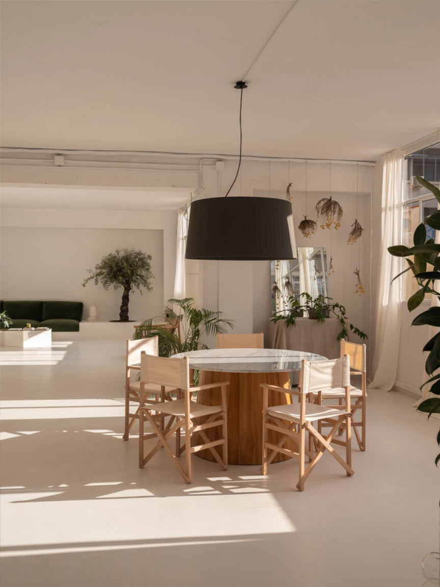 Modern dining area with a round table and chairs in a bright room.