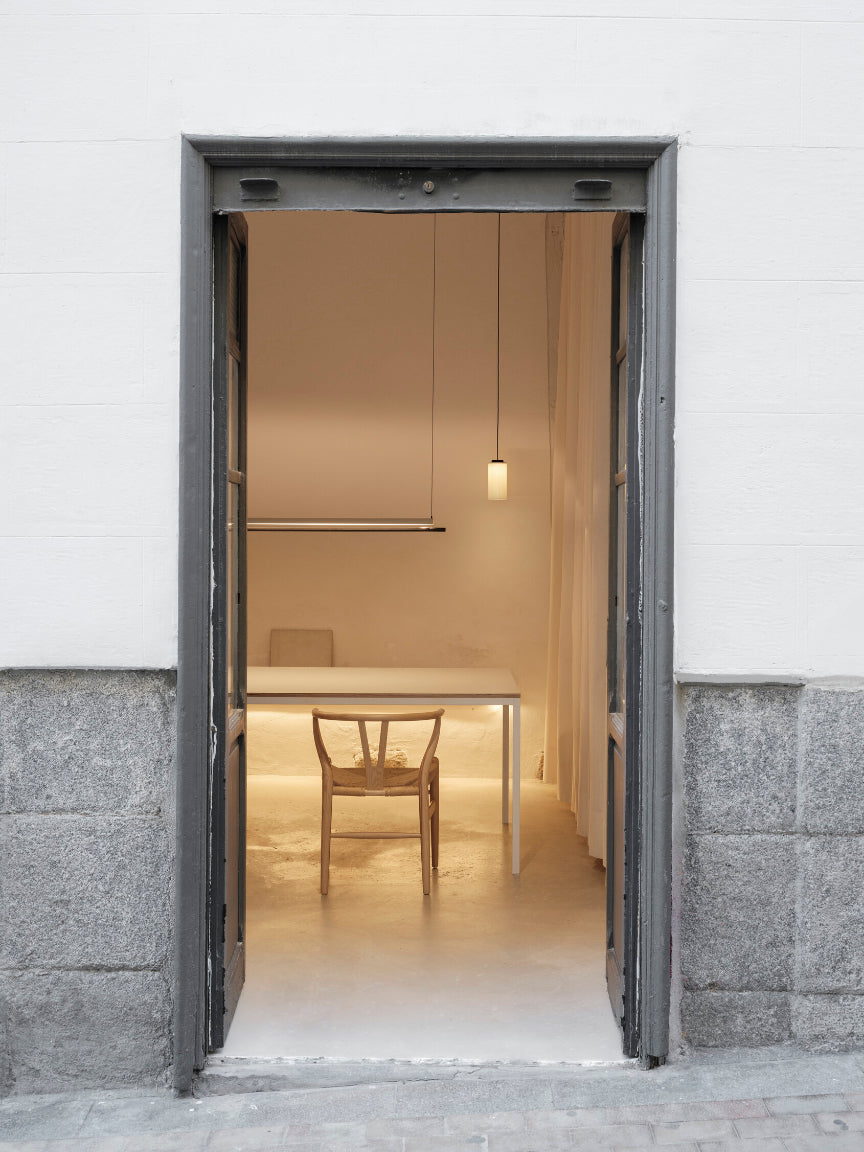 Open door leading into a softly lit room with a table and chair.