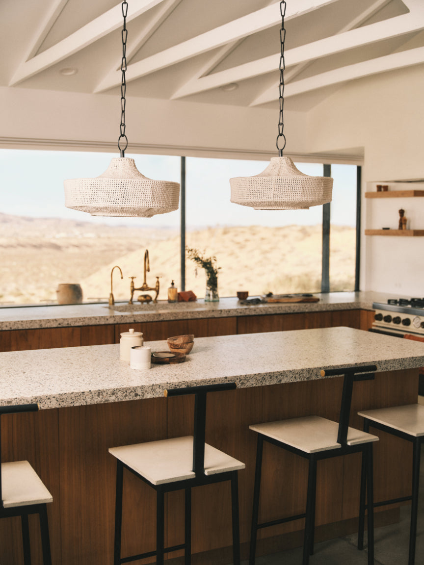 Modern kitchen with pendant lights, granite countertops, and a view of the desert.
