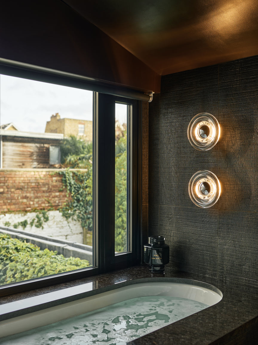 Tom Dixon glass wall sconce in bathroom