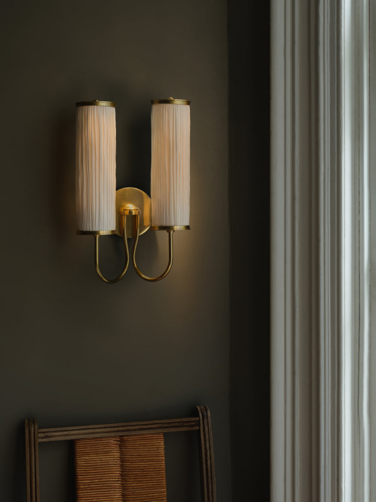 Wall-mounted lamp with pleated shades on a dark wall